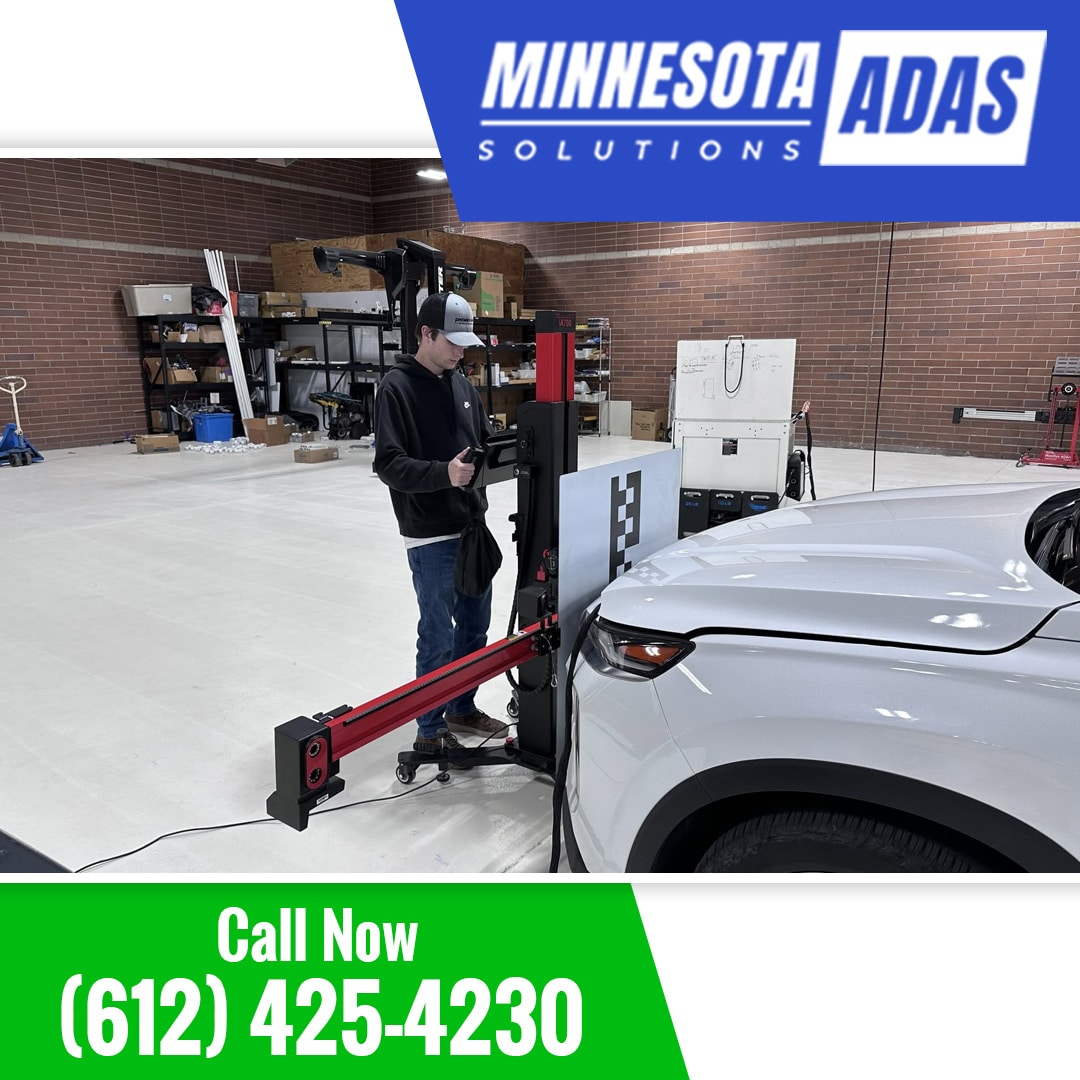 Certified technician using a specialized digital ADAS calibration target system positioned directly in front of a white SUV.