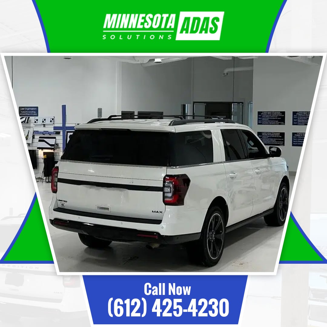 White full-size SUV parked inside a professional, clean automotive ADAS calibration service bay.